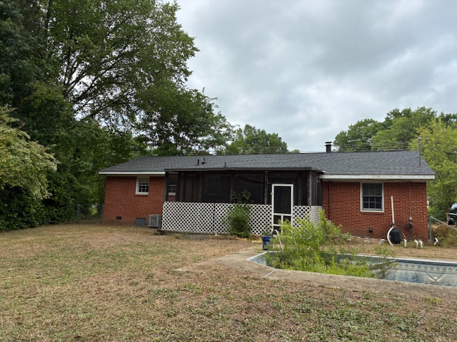 Back of brick home and pool area